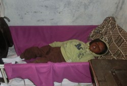 Während seine Mutter arbeitet, liegt Amos in einem Gitterbett in der Schneiderstube.