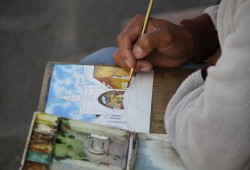 Ein Straßenkünstler zeichnet den kolonialen Charme der guatemaltekischen Städte nach.