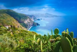 Aussicht auf das Meer über grüne Hänge und fruchtbare Natur auf den Liparischen Inseln in Italien