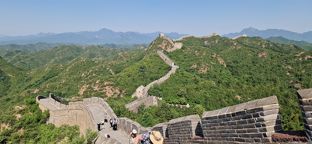 Chinesische Mauer bei Sonnenschein, Berge im Hintergrund