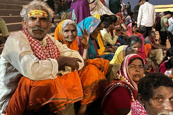 indische Menschen sitzen am Ufer des Ganges
